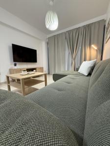een woonkamer met 2 bedden en een flatscreen-tv bij Abitare Retreat in Paphos City