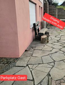 een bankje naast een roze gebouw met een bordje bij Modern trifft Antik in Wendershausen