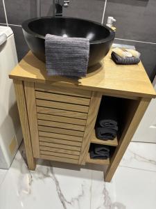 博韦Jungle house,Arr autonome,Proche Aéroport & Gare的浴室里一个黑色碗状洗手盆，放在木架上。 更多8张照片