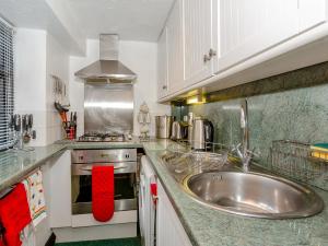 a kitchen with a sink and a stove at Ginny's Cottage in Haworth