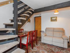 a living room with a staircase and a table and a couch at Ginny's Cottage in Haworth