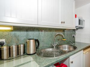a kitchen counter with a sink and a microwave at Ginny's Cottage in Haworth