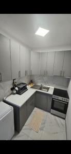Una pequeña cocina con fregadero y estufa. en TM Apartment Prijedor, en Prijedor