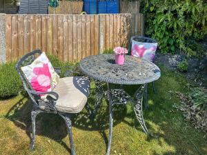 une table et une chaise avec un vase dessus dans l'établissement Lavender Cottage, à Frinton-on-Sea 9 autres photos