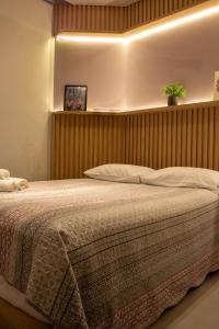 ein Schlafzimmer mit einem großen Bett mit einem hölzernen Kopfteil in der Unterkunft Book Santos - Estanconfor 1407 - Vista Mar lateral in Santos