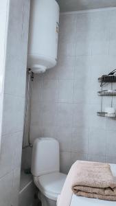a white bathroom with a toilet and a light at Олександрійський б-р 125 CityRooms in Bila Tserkva +21 photos