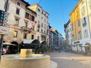 a fountain in the middle of a street with buildings at Sky House Sant'Orsola in Bergamo