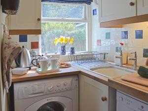 a kitchen with a washing machine and a sink at Nell's Cottage in Askam in Furness