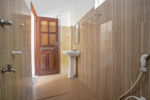a bathroom with a sink and a wooden door at Medawatta Villa in Mirissa
