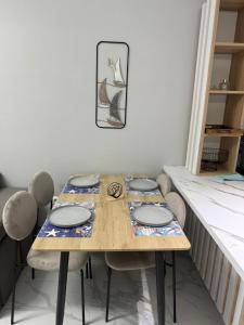 a table with four chairs and a picture on the wall at Luxury Apartment Orikum in Orikum