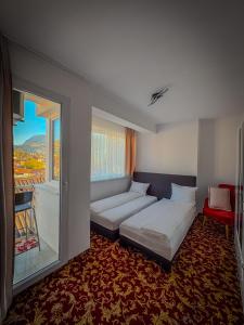 een slaapkamer met twee bedden en een groot raam bij Residence Mahala - Boutique Guesthouse near Baščaršija in Sarajevo