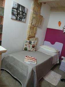 a small bed in a room with a wall at La casa di Dea in Marsala
