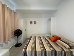 a bedroom with a large bed with an orange pillow at Apto térreo em Tijucas n 04 in Tijucas