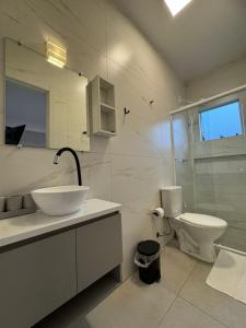 a white bathroom with a sink and a toilet at Apto térreo em Tijucas n 04 in Tijucas +31 photos