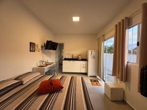 a bedroom with a bed with a orange pillow on it at Apto térreo em Tijucas n 04 in Tijucas