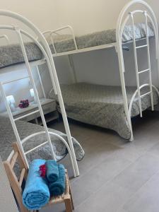 a room with bunk beds and a chair with a towel at Villa Nido dei Passeri in Calasetta +59 photos