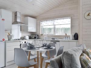 a kitchen with a table and chairs in a kitchen at The Den in Etteridge