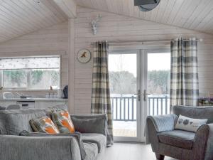 a living room with two couches and a kitchen at The Den in Etteridge