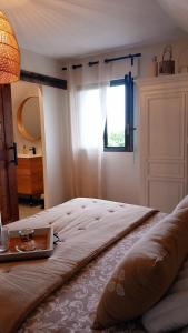 Un dormitorio con una cama con una mesa y una ventana. en BOCENNO Catherine, en Ambon