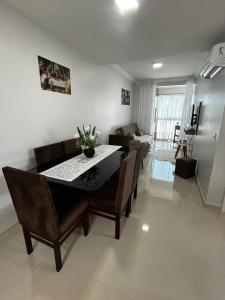 ein Esszimmer und ein Wohnzimmer mit Tisch und Stühlen in der Unterkunft AP Novinho! à 150m das piscinas! 3 ar cond - churrasqueira in Piratuba
