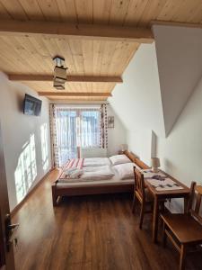 a bedroom with a bed and a table with chairs at Willa WIDOKOWA CUDZICH in Zakopane