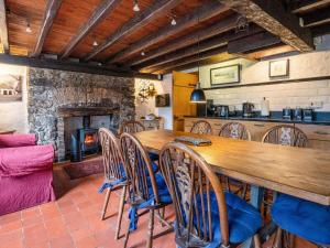 uma sala de jantar com uma mesa longa e uma lareira em The Old Smithy - Cottage em Llanfaes