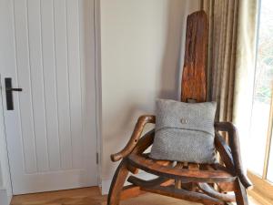 a wooden rocking chair with a pillow on it at Fig Cottage in Brabourne +6 photos