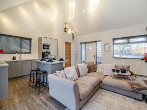 un salon avec un canapé et une cuisine dans l'établissement Ferndale Bungalow, à Hambleton