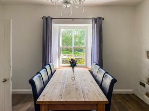 ein Esstisch mit Stühlen und ein Fenster in der Unterkunft The Farmhouse in Pelcomb