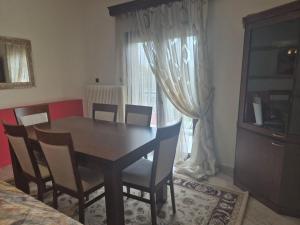 a dining room with a table and chairs and a window at Casa del Campo Trikala in Chrysavgí