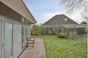 a porch of a house with a bench and a yard at Villa Dune I in Ouddorp