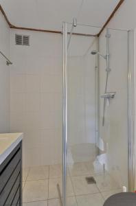 een badkamer met een douche met een glazen deur bij Villa Dune I in Ouddorp +35 foto's
