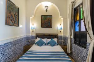 a bedroom with a bed with blue and white tiles at Riad Arabesque in Marrakech +62 photos