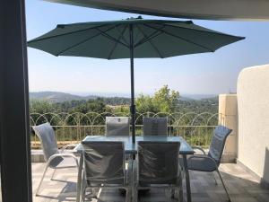 a table and chairs with an umbrella on a balcony at Exotic Vacation in the Jerusalem Mountains in Shoresh