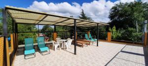 un patio avec des chaises et une table et un toit dans l'établissement Cabañas Alünmew, à Juana Koslay 