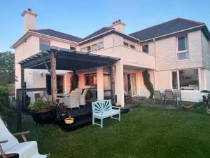 a house with a pergola and chairs in the yard at Ocean Lodge B&B in Renvyle