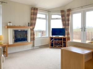 West DownにあるGrandma's Stick Houseのリビングルーム(テレビ、ソファ付)