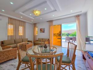 a living room with a glass table and chairs at Tezdaine's garden in Bin Rhilouf