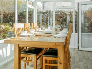 a wooden dining room table with chairs and a tableastery at Drumwherry By The Sea in Monreith +15 photos