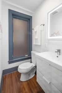 a white bathroom with a toilet and a sink at 2BR Capitol hill delight, with private parking in Washington +16 photos