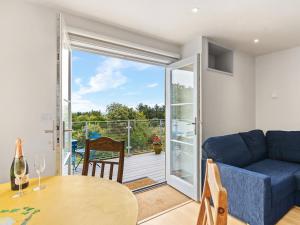 ein Wohnzimmer mit einem blauen Sofa, einem Tisch und einem Balkon in der Unterkunft Rogestons House in Nolton