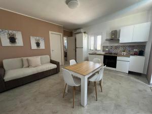 Una cocina y una sala de estar con una mesa y un sofá. en Villa Gallieco, en Noto