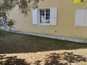 een raam aan de zijkant van een huis bij L' amandier in Teyran