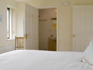 une chambre avec un lit blanc et un lavabo dans l'établissement Bramley Cottage - Ukc1701, à Brean 3 autres photos