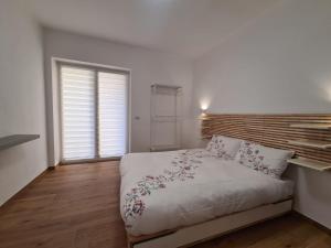 a bedroom with a white bed with a wooden headboard at La Casa di Nonna in Conversano