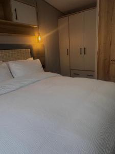 a bedroom with a large white bed and cabinets at Sheepfold lodge in Sedbergh +19 photos