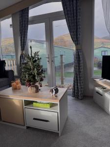 a living room with a table with a christmas tree on it at Sheepfold lodge in Sedbergh
