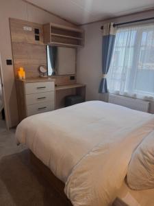 a bedroom with a bed and a desk and a television at Sheepfold lodge in Sedbergh