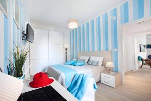 a bedroom with a bed with blue and white stripes at Mare Sunset & Relax in Meta