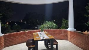 a table and two chairs on a patio at night at Jacaranda Escape 4 x King Bed 3 Bath House in Pretoria